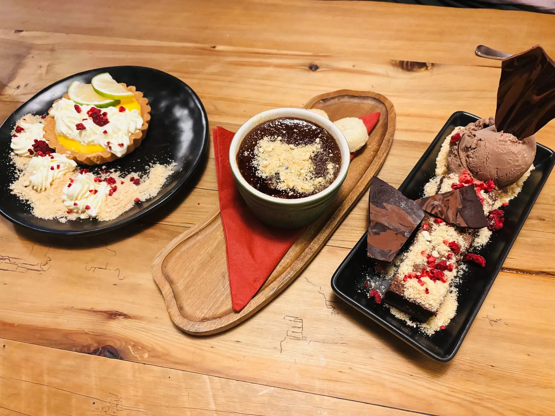 A dessert board: lemon tart, chocolate pot and brownie with ice cream