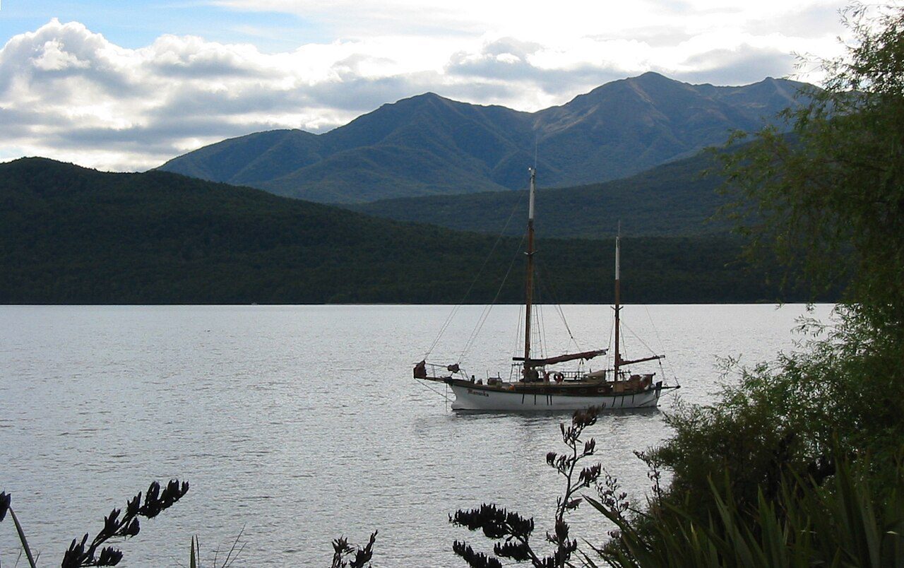 Sailboat moored on Lake Te Anau with mountains beyond